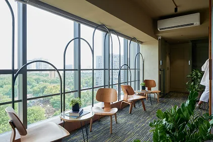 Arched window lounge with Eames chairs and city skyline
