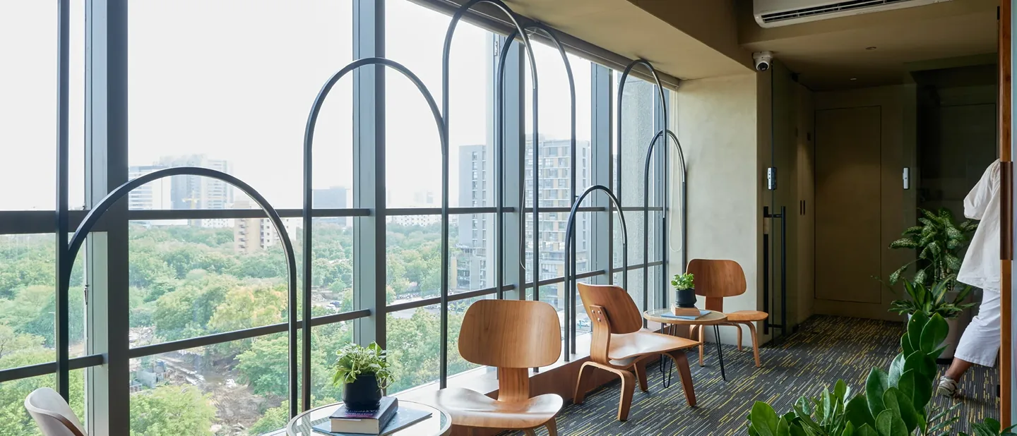 Coffee In-House Office — arched window lounge with skyline views