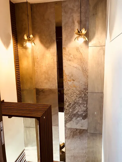 Brass lotus pendant lights on marble stairwell wall
