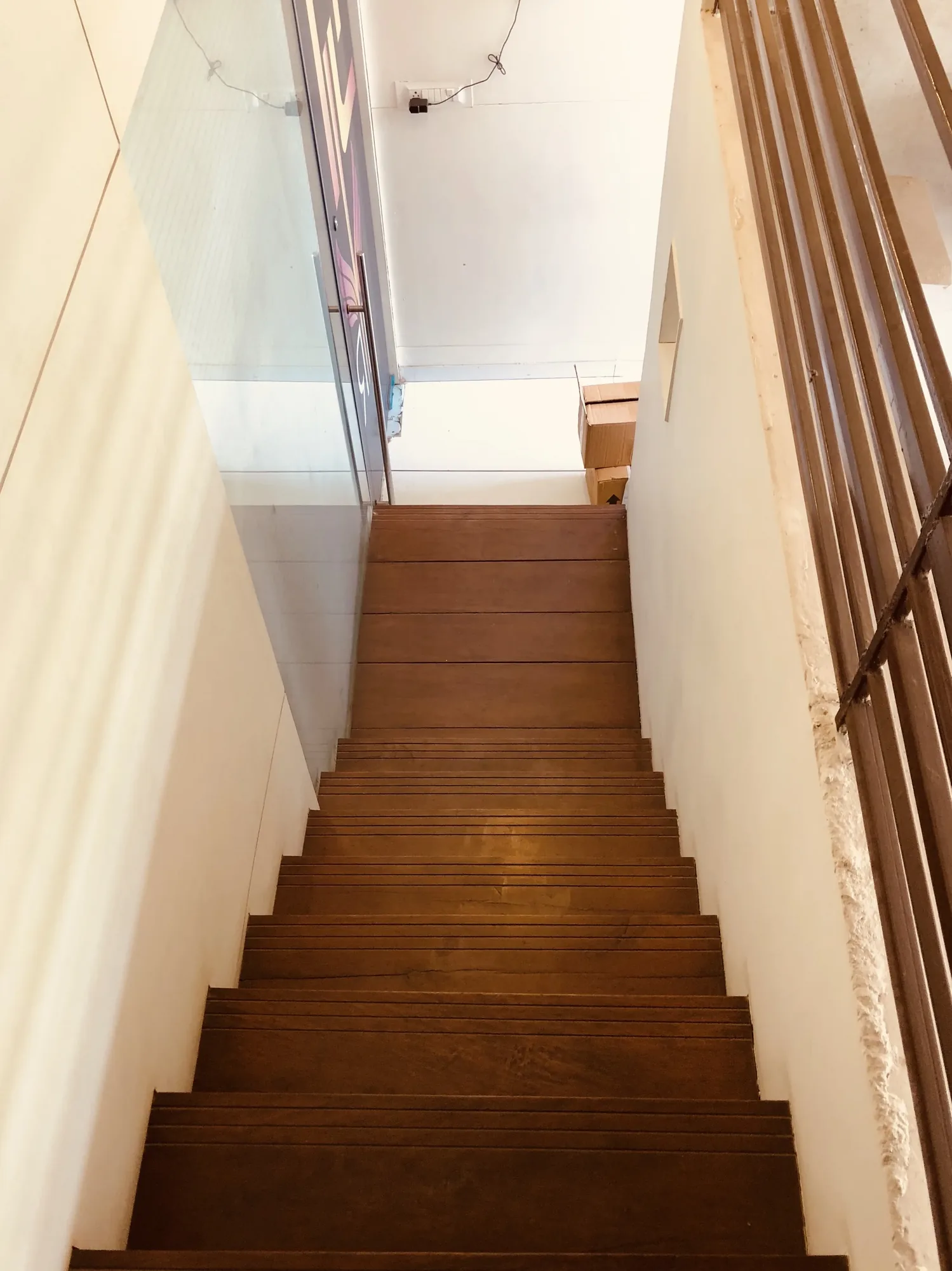 The Box Salon — sculptural wooden staircase joining the two levels