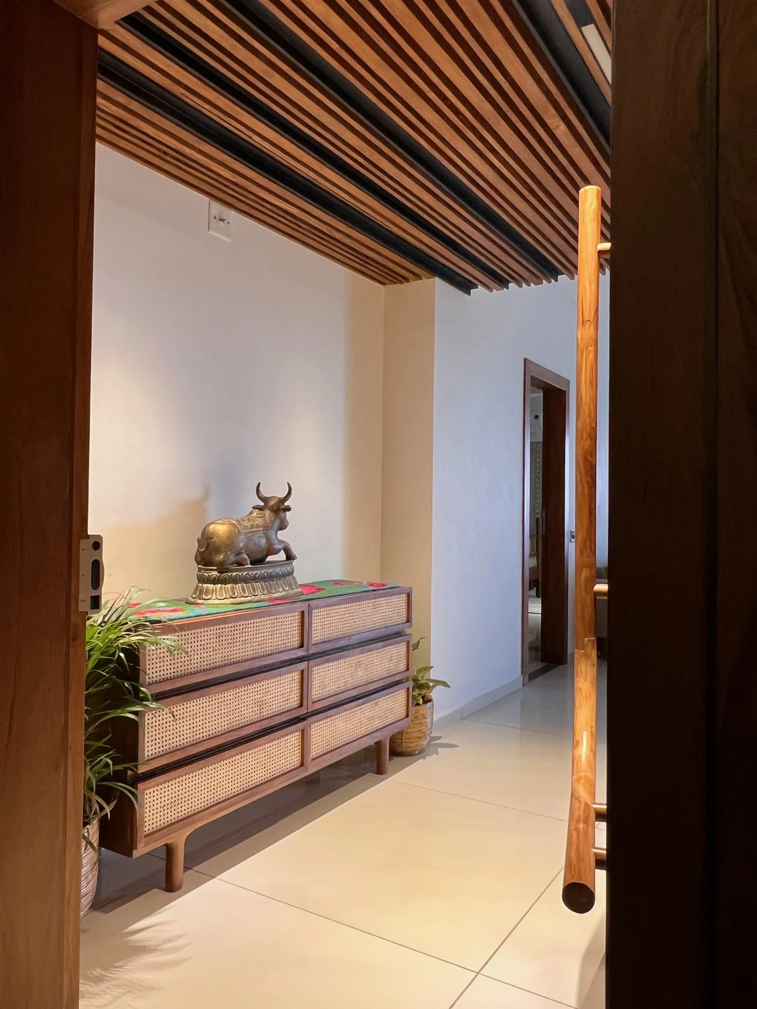 Entryway cane sideboard with Nandi statue